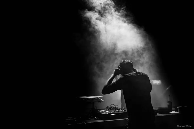DJ Nils Janssen am DJ-Pult im Bühnenlicht